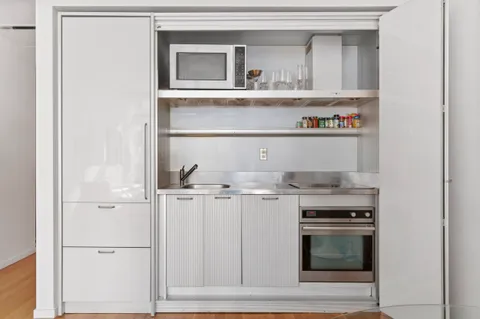 a kitchen with white cabinets and appliances