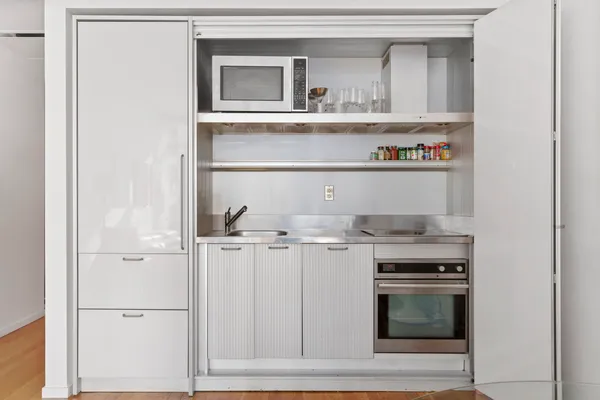 a kitchen with white cabinets and appliances