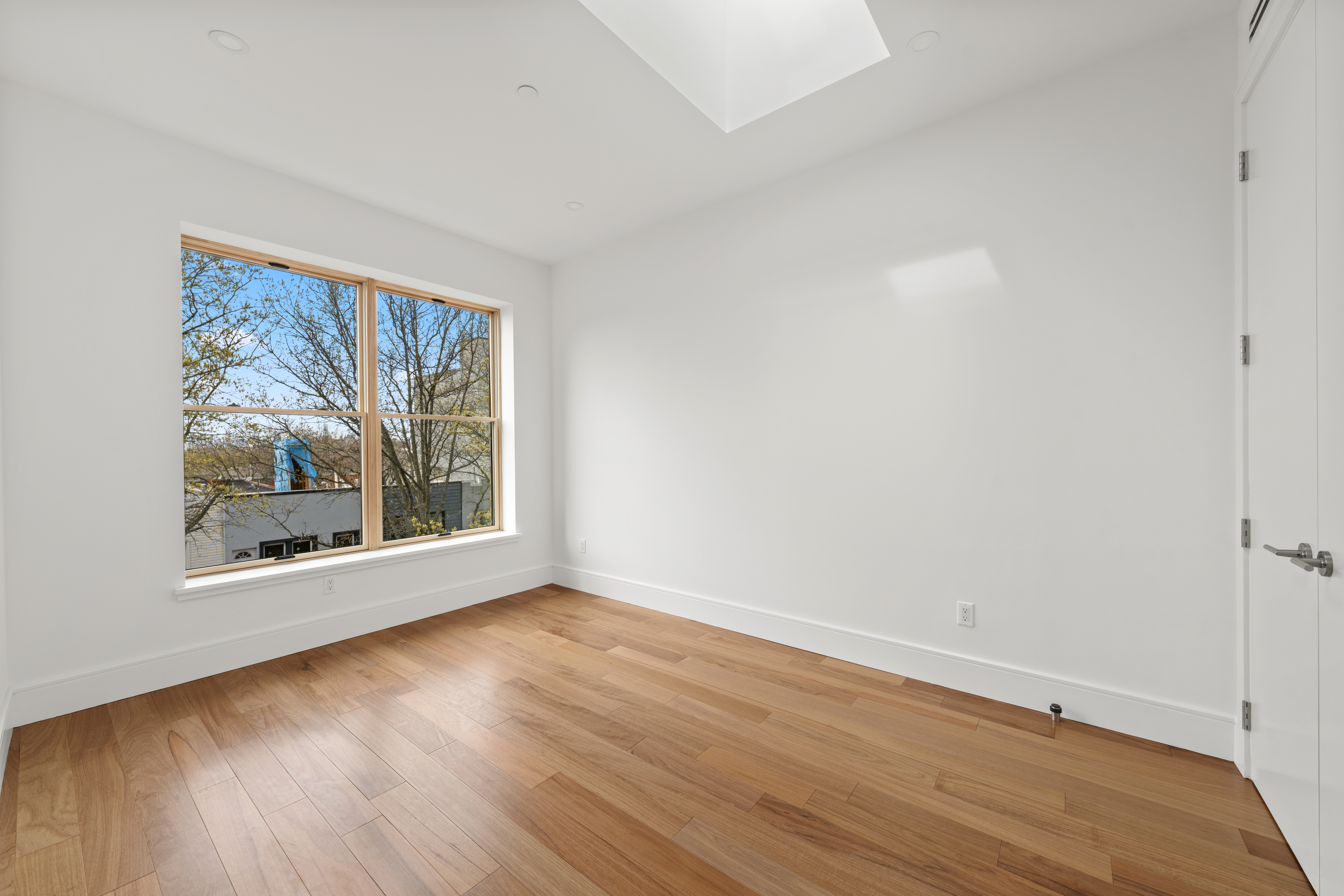 82 Cooper Street, Unit 3A Brooklyn, NY 11207 - Photo 5 of 17 a view of an empty room with wooden floor and a window