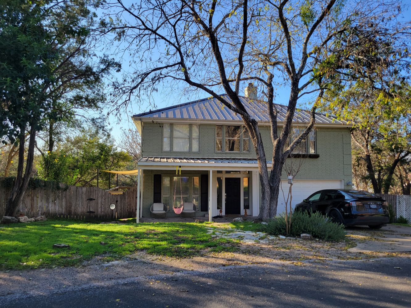 a front view of a house with a garden and trees