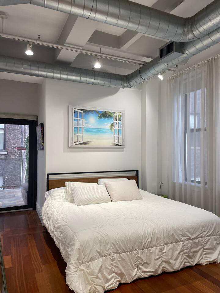 43-45 East 30th Street, Unit 8D Manhattan, NY 10016 - Photo 7 of 11 a bedroom with a large bed and wooden floor