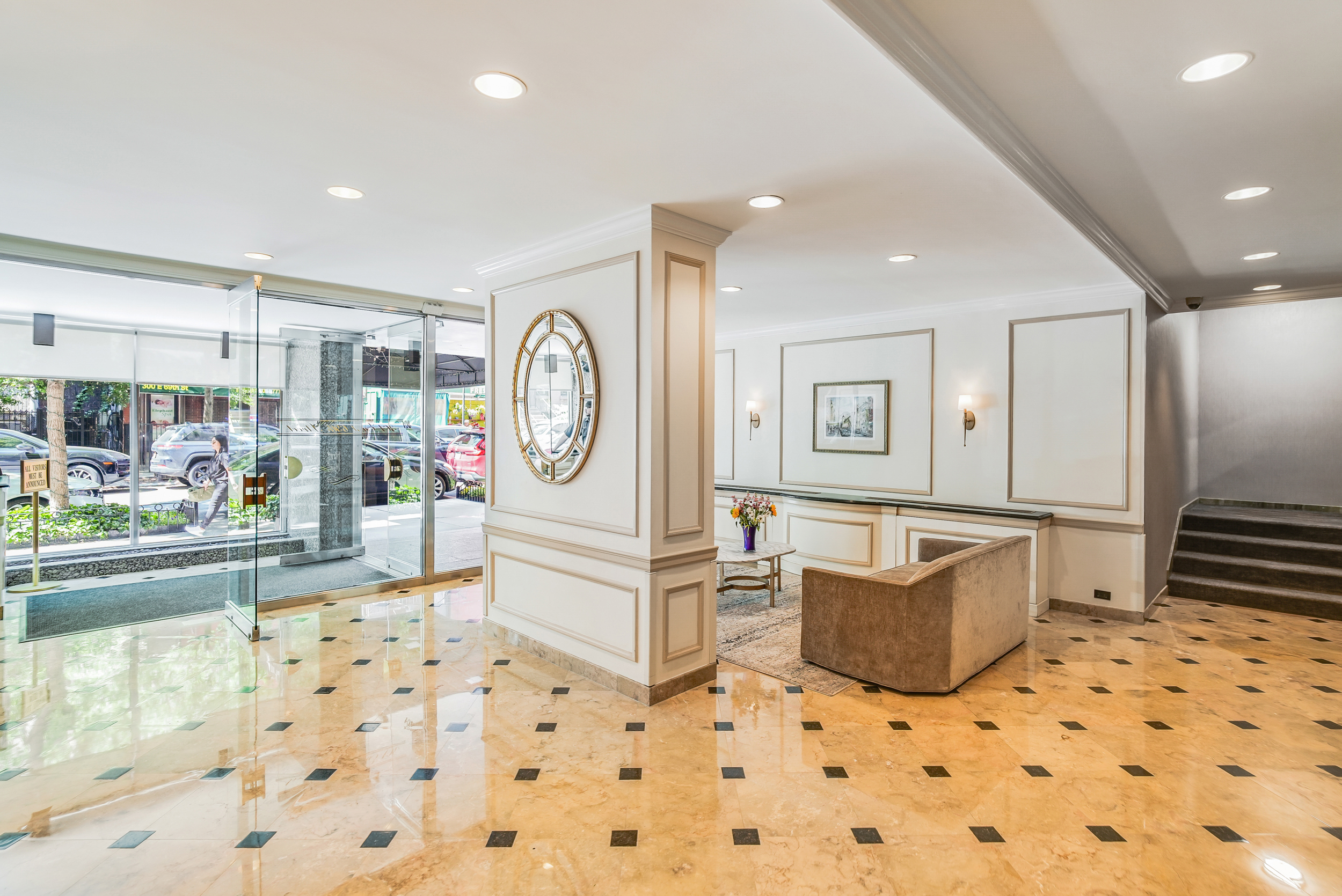 301 East 69th Street, Unit 3M Manhattan, NY 10021 - Photo 10 of 12 a living room with furniture a clock and a view of kitchen