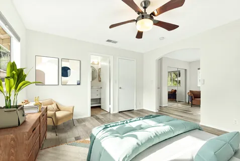 a bedroom with a large bed couch and a window