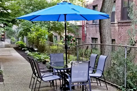 a patio with a table and chairs under an umbrella