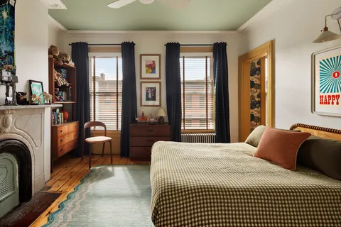 a bedroom with a bed couch and windows