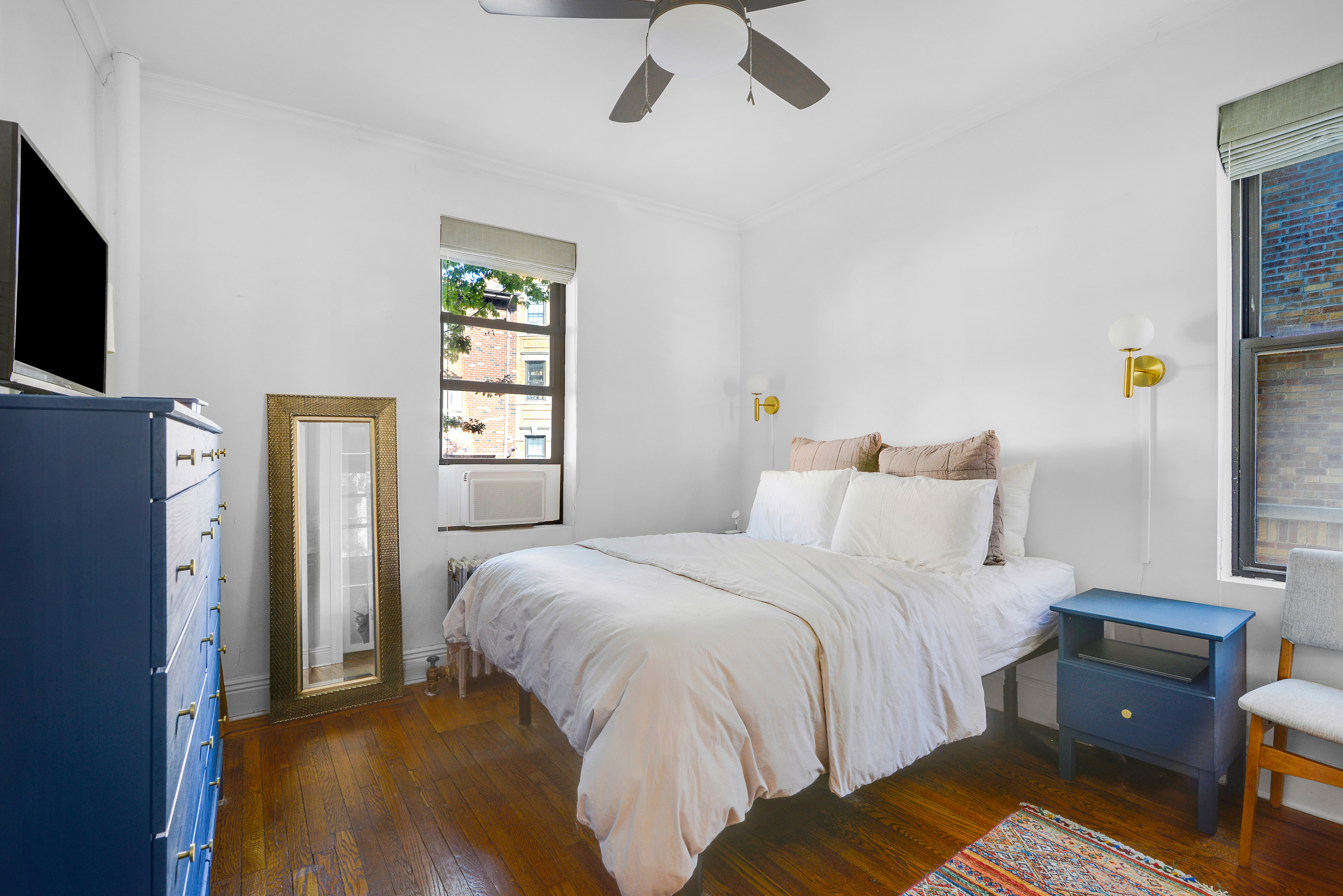 24-75 38th Street, Unit A1 Queens, NY 11103 - Photo 5 of 12 a bedroom with a bed and a flat tv screen on a dresser