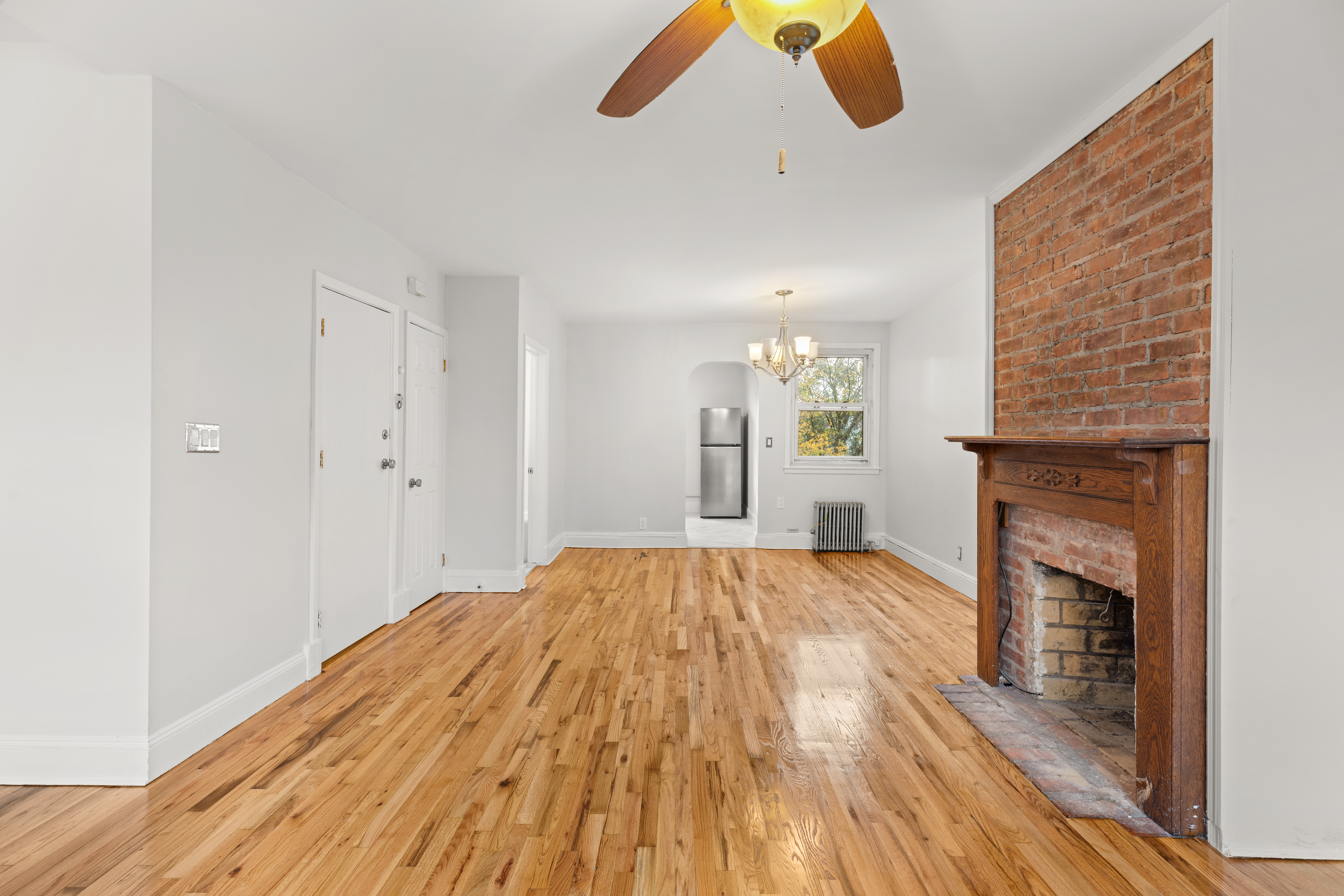 180 East 5th Street, Unit 2 Brooklyn, NY 11218 - Photo 3 of 14 a view of empty room with wooden floor and fireplace