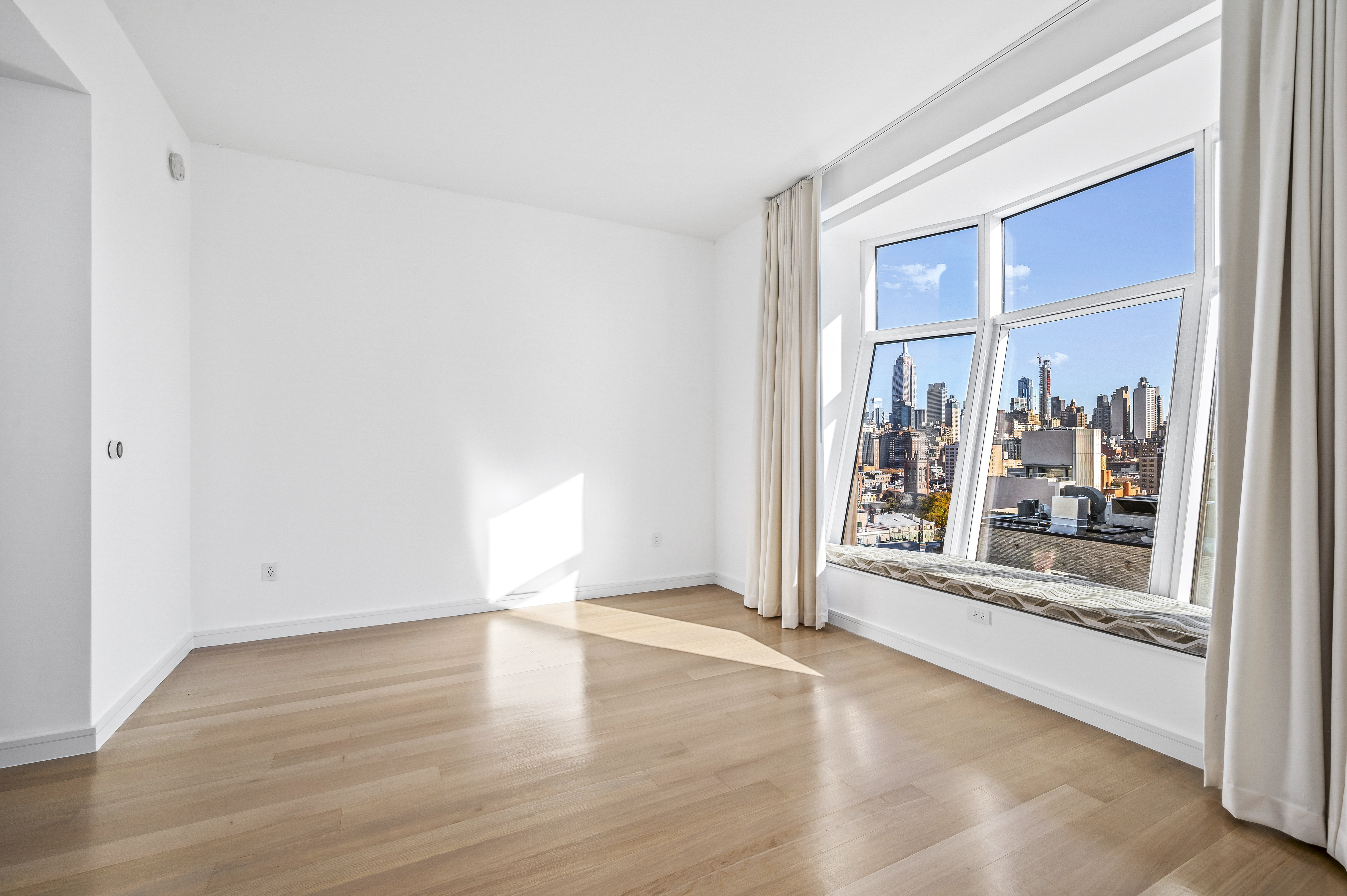 515 West 18th Street, Unit 1401 Manhattan, NY 10011 - Photo 10 of 12 an empty room with wooden floor and windows