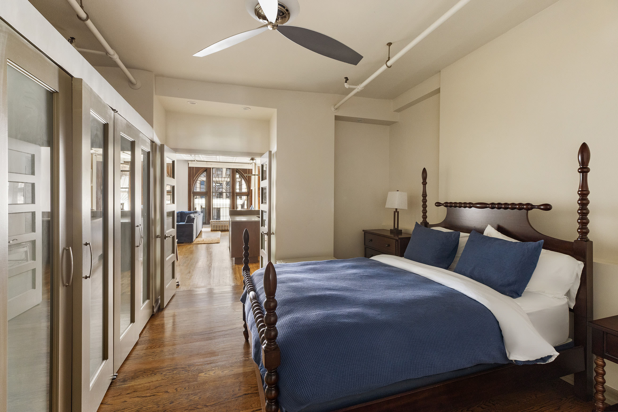 133-131 West 28th Street, Unit 2A Manhattan, NY 10001 - Photo 5 of 7 a bedroom with a large bed and a chandelier
