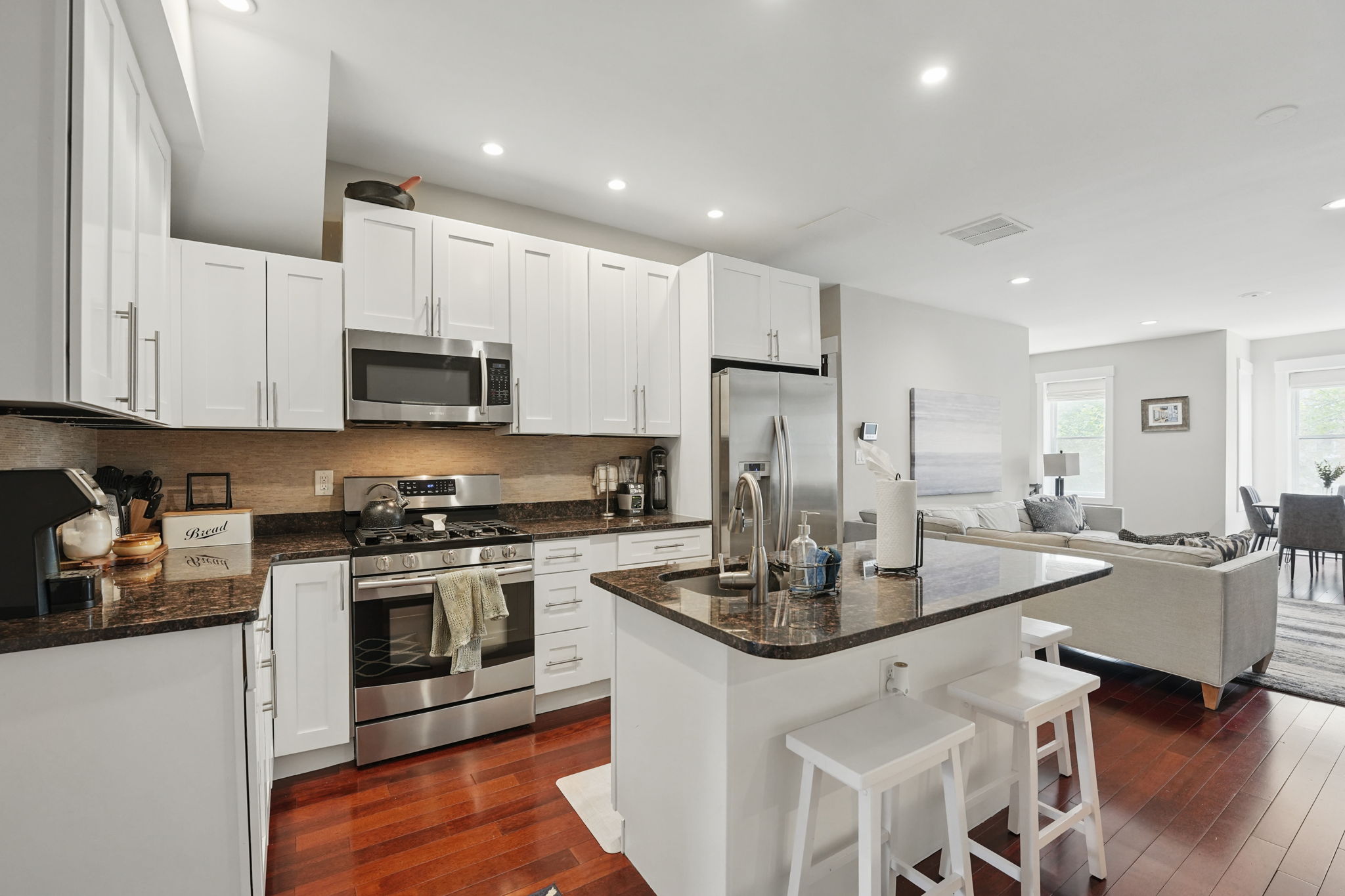 28 Q Street Northeast, Unit 2 Washington, DC 20002 - Photo 12 of 41 a kitchen with stainless steel appliances granite countertop a stove a sink a refrigerator a microwave and white cabinets