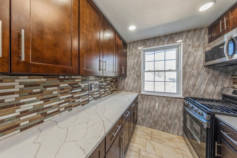 224-46 Horace Harding Expressway, Unit 630 Queens, NY 11364 - Photo 15 of 29 a kitchen with granite countertop a sink and a stove