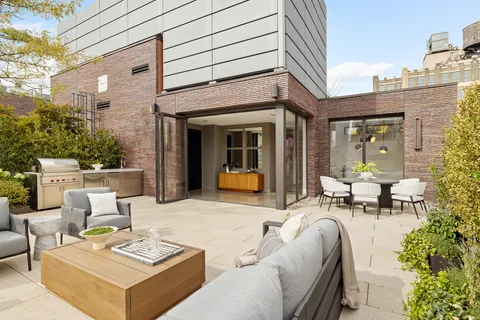 a view of a patio with couches table and chairs and potted plants