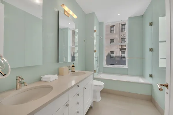 a bathroom with a double vanity sink mirror double and bathtub