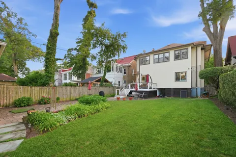 a view of a house with backyard and a tree