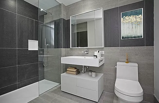 540 West 49th Street, Unit 407N Manhattan, NY 10019 - Photo 2 of 12 a bathroom with a sink toilet a mirror and shower