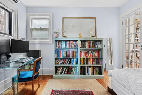a view of a workspace with furniture and a bookshelf