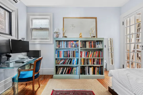 a view of a workspace with furniture and a bookshelf