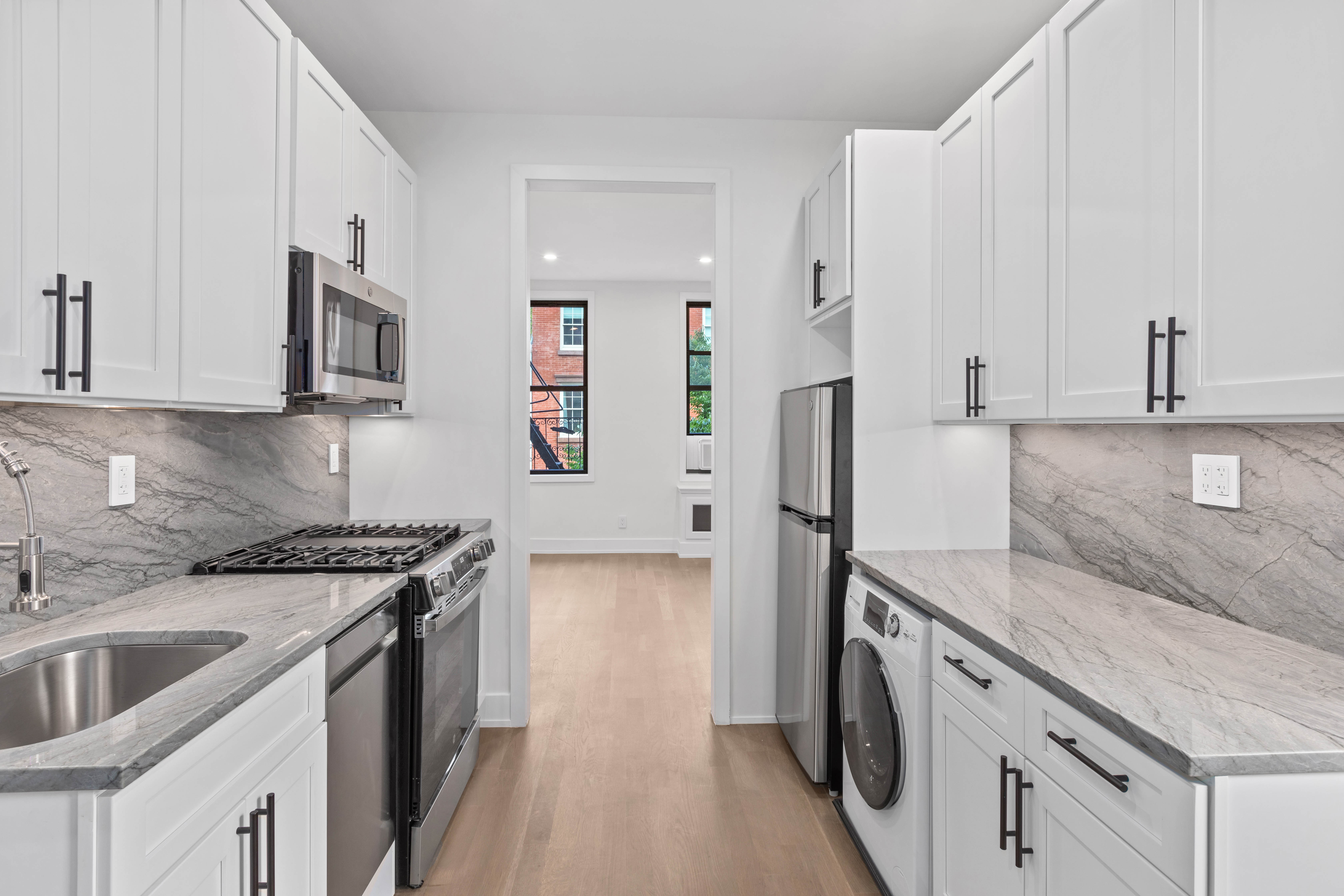 64 MacDougal Street, Unit 7 Manhattan, NY 10012 - Photo 2 of 5 a kitchen with stainless steel appliances granite countertop a sink stove and refrigerator