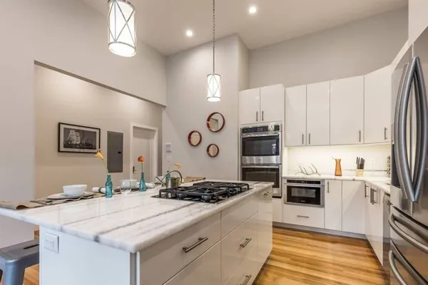 a kitchen with stainless steel appliances granite countertop a sink stove and refrigerator