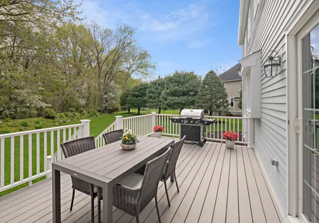a balcony with wooden floor table and chairs