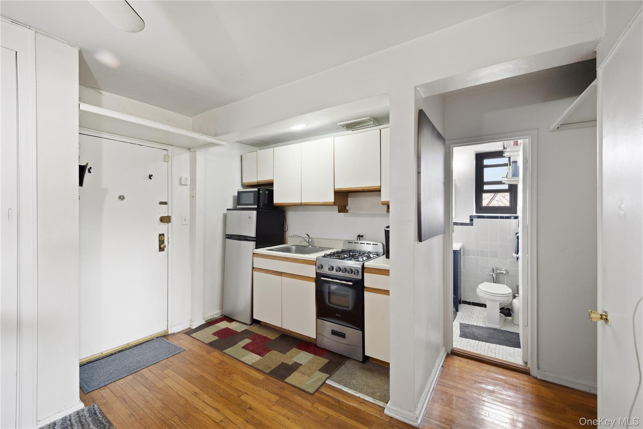 73-11 Bell Boulevard, Unit 2C Queens, NY 11364 - Photo 11 of 16 a kitchen with stainless steel appliances granite countertop a refrigerator and a stove top oven