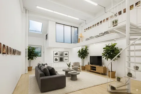 a living room with furniture a potted plant and a fireplace