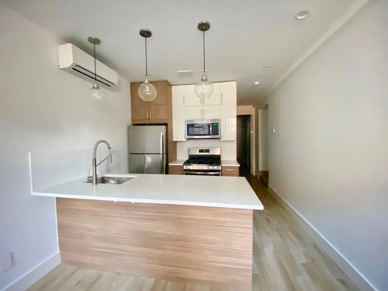 a kitchen with kitchen island a counter top space appliances and a sink