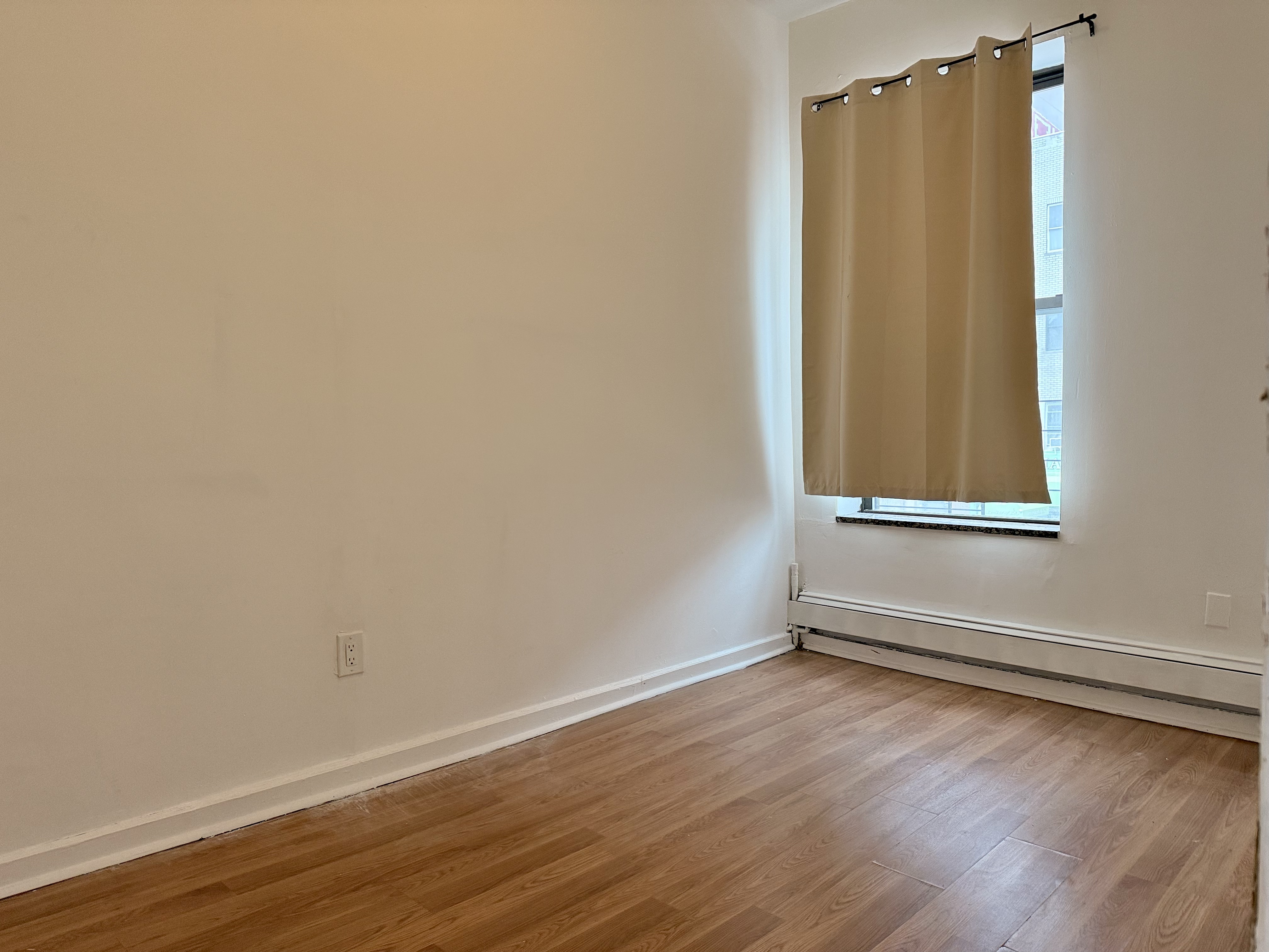 1997 3rd Avenue, Unit 1A Manhattan, NY 10029 - Photo 7 of 23 a view of a room with wooden floor and white walls