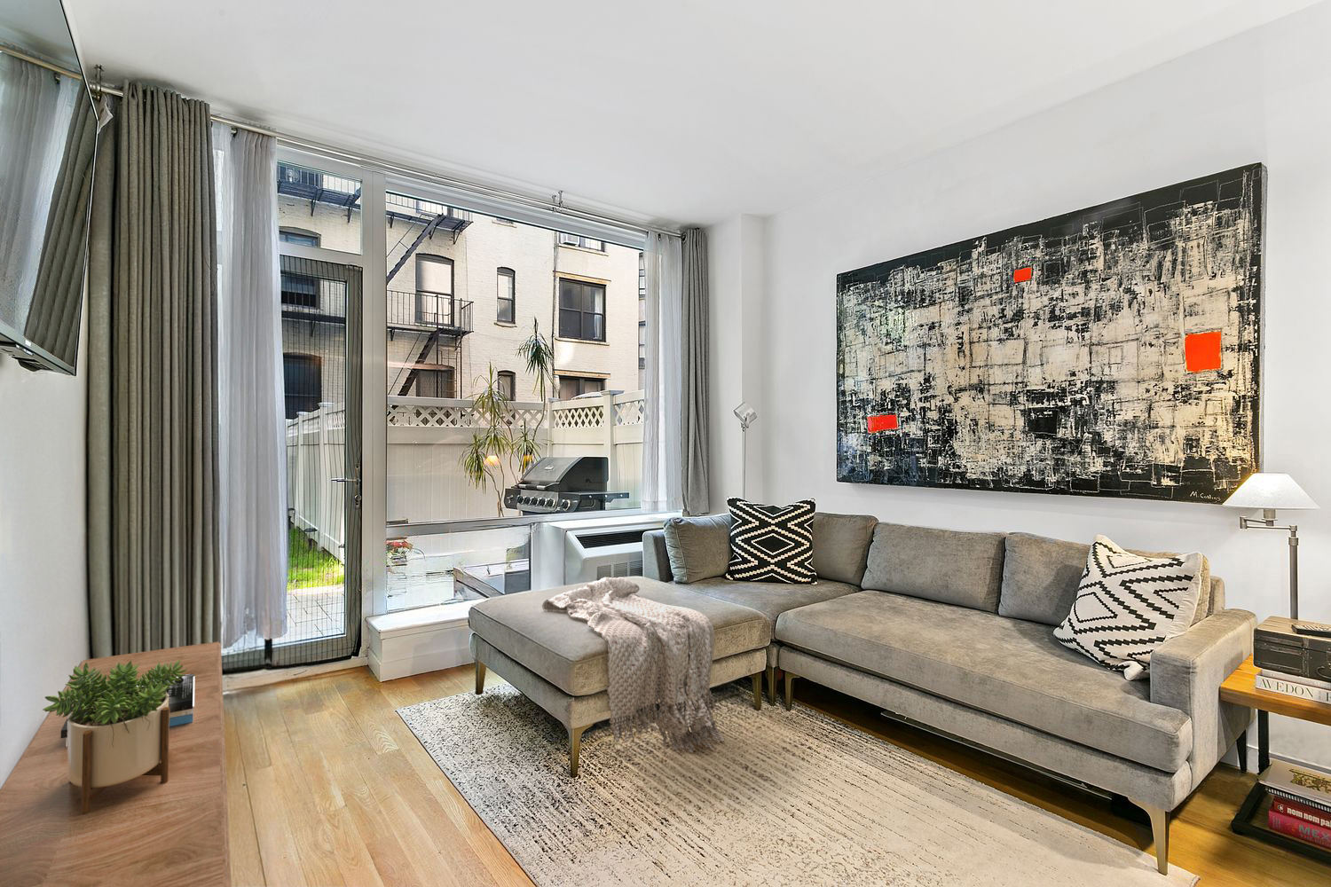 306 West 116th Street, Unit 1B Manhattan, NY 10026 - Photo 2 of 14 a living room with furniture and a large window