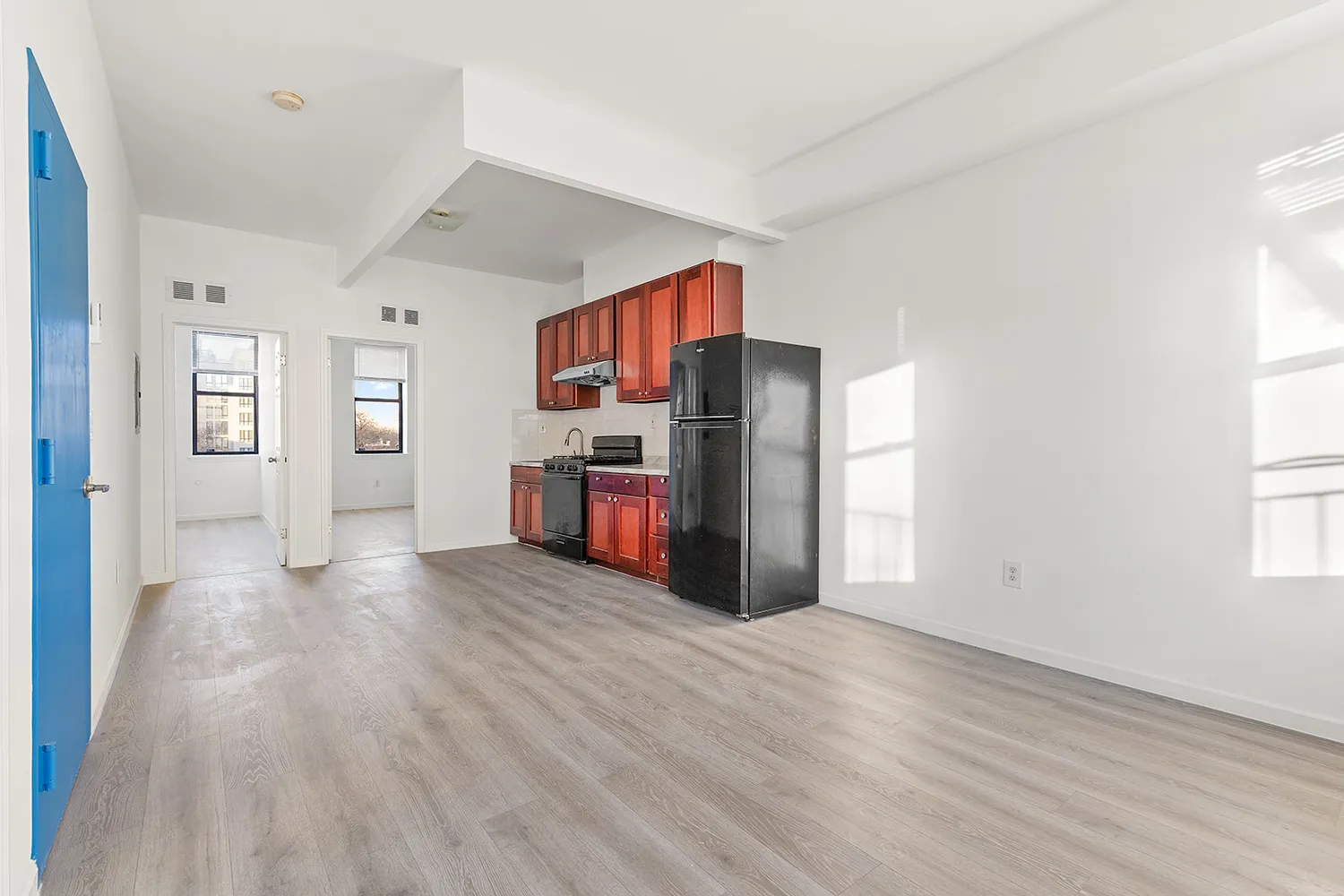 a view of a kitchen with wooden floor and electronic appliances