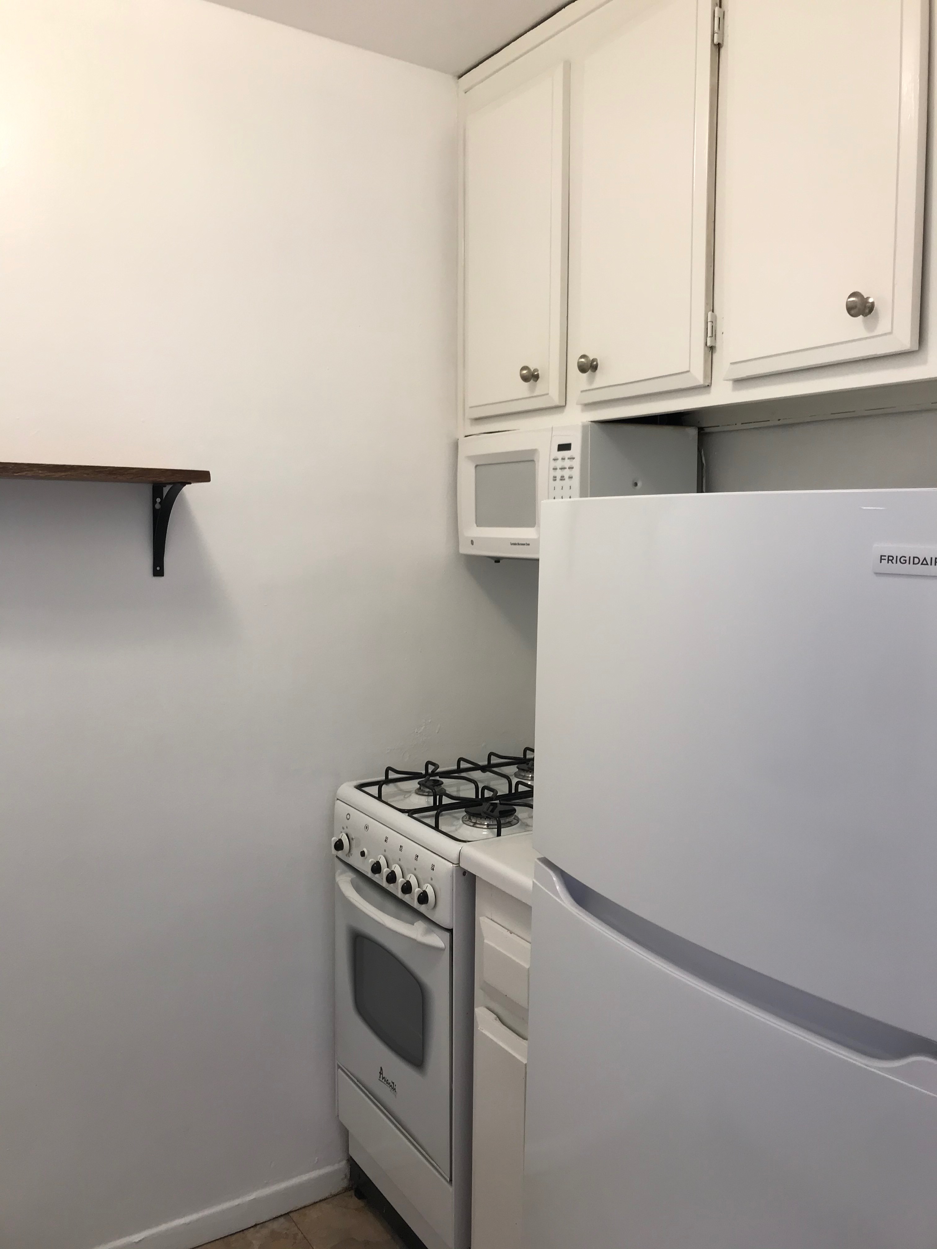 301 East 22nd Street, Unit 5G Manhattan, NY 10010 - Photo 4 of 10 a view of kitchen with white cabinets and white appliances