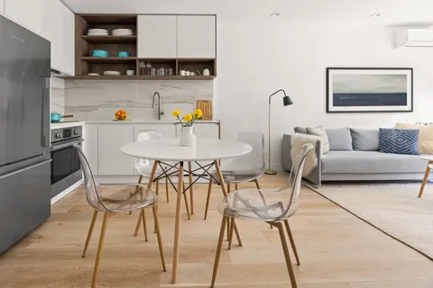 a view of a dining room with furniture and a kitchen