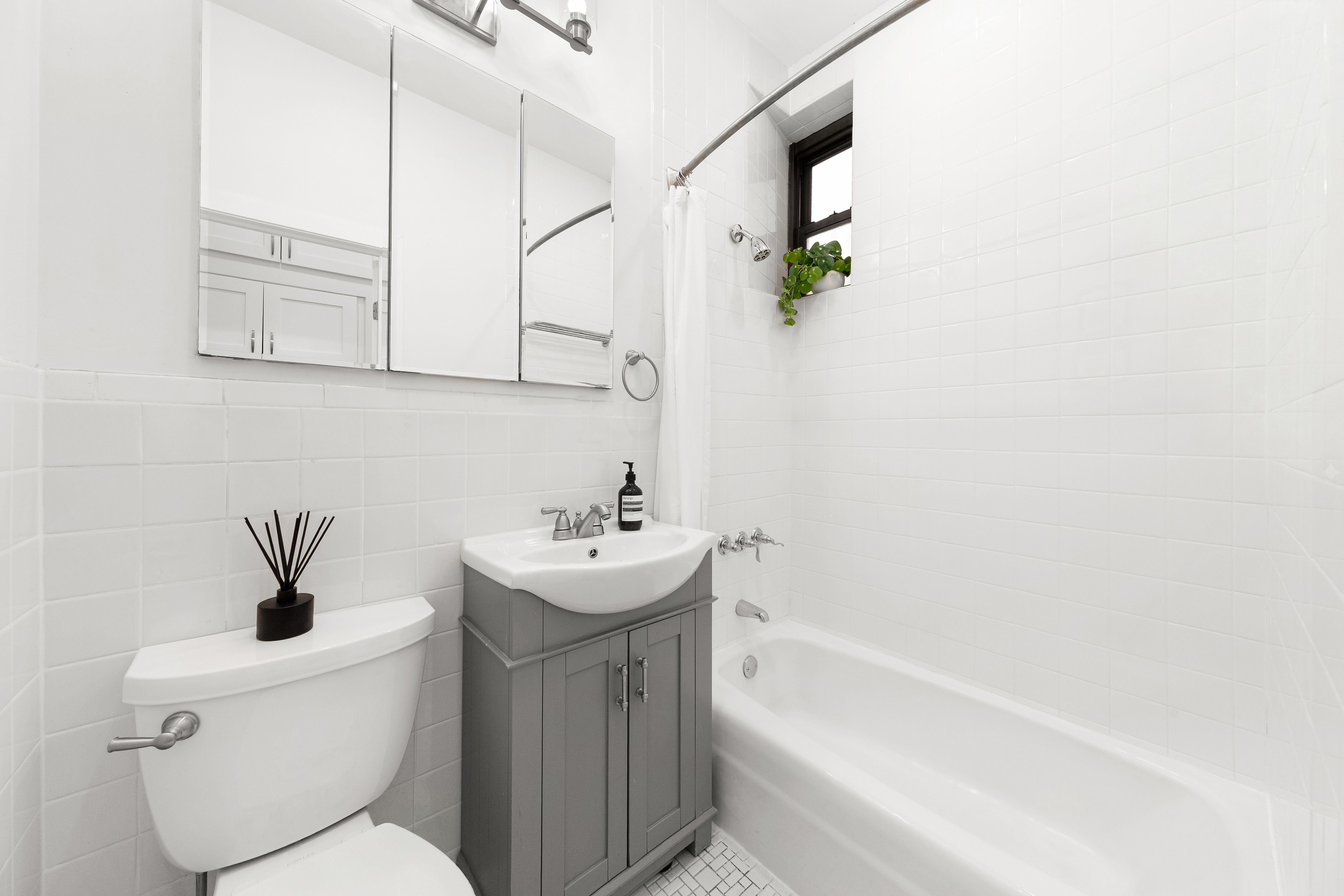 170 East 92nd Street, Unit 1D Manhattan, NY 10128 - Photo 10 of 12 a bathroom with a sink a toilet and shower
