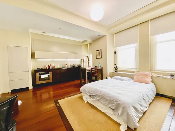 a bedroom with a bed and wooden floor