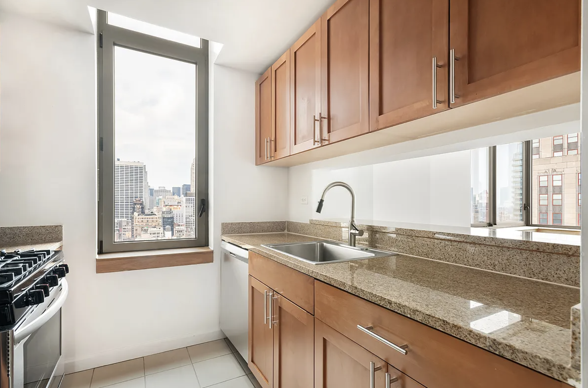 35 West 33rd Street, Unit 32C Manhattan, NY 10001 - Photo 7 of 21 a kitchen with granite countertop a sink and a window