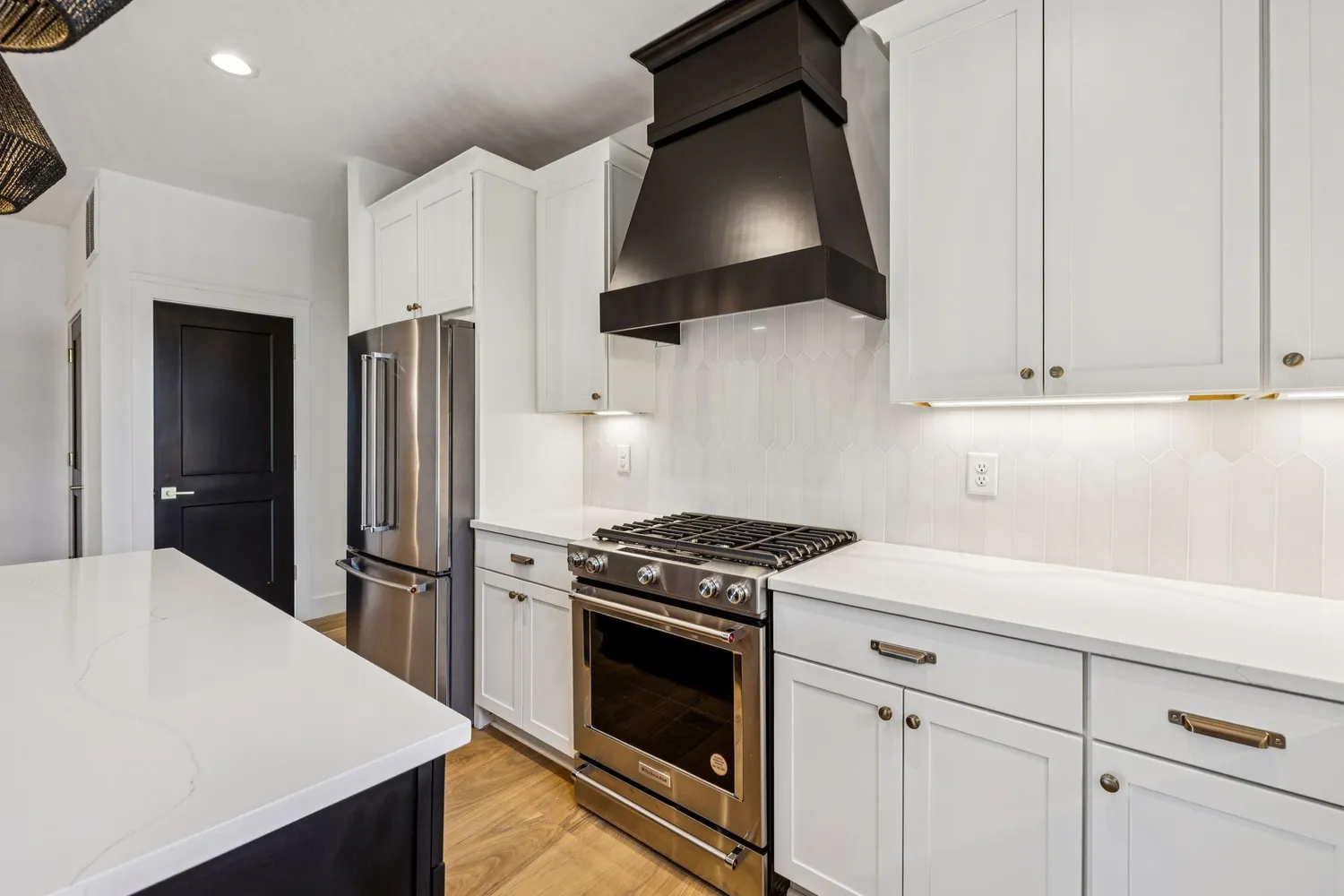 a kitchen with stainless steel appliances white cabinets and a stove top oven