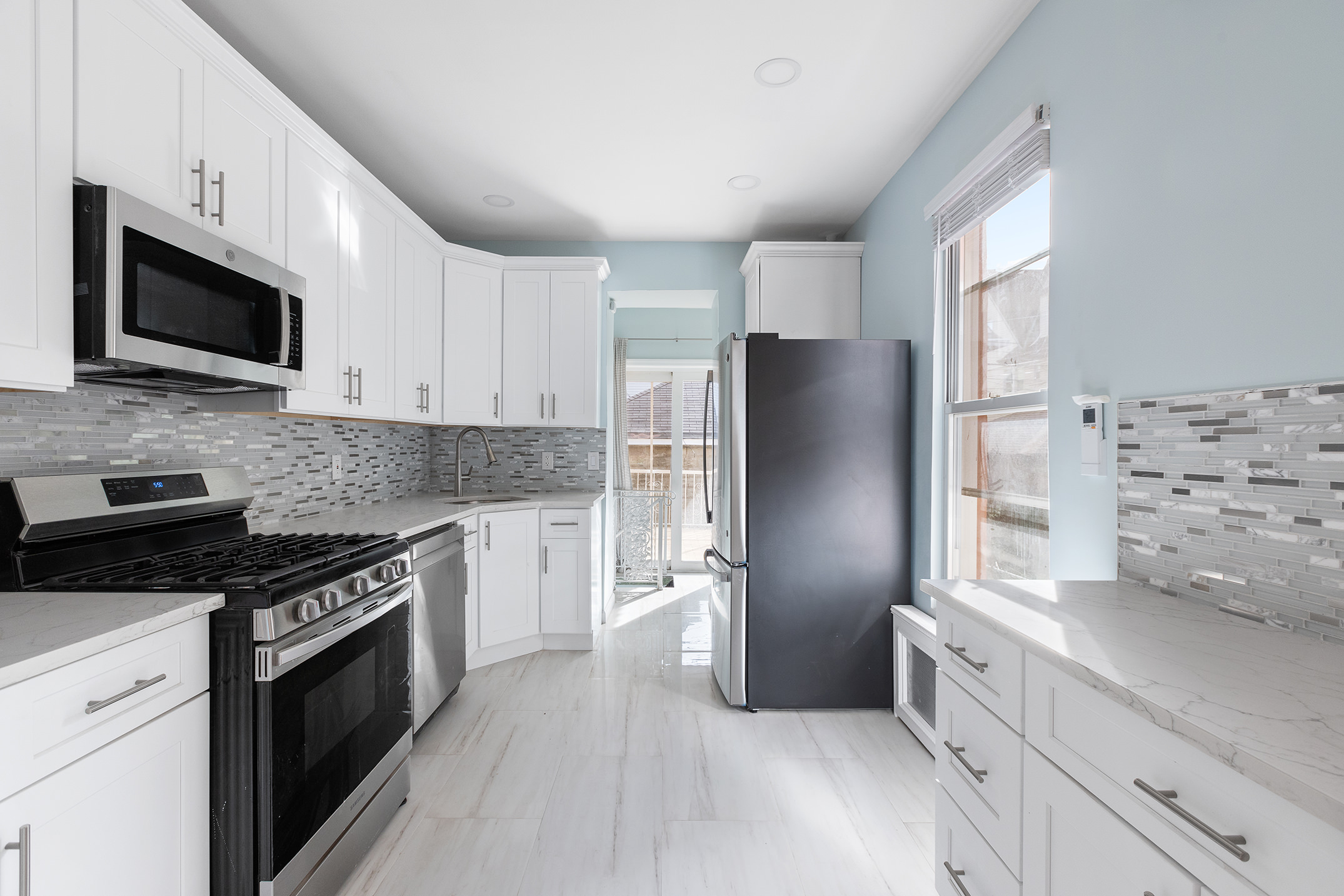 2773 Bedford Avenue Brooklyn, NY 11210 - Photo 5 of 17 a kitchen with stainless steel appliances a refrigerator stove microwave and sink