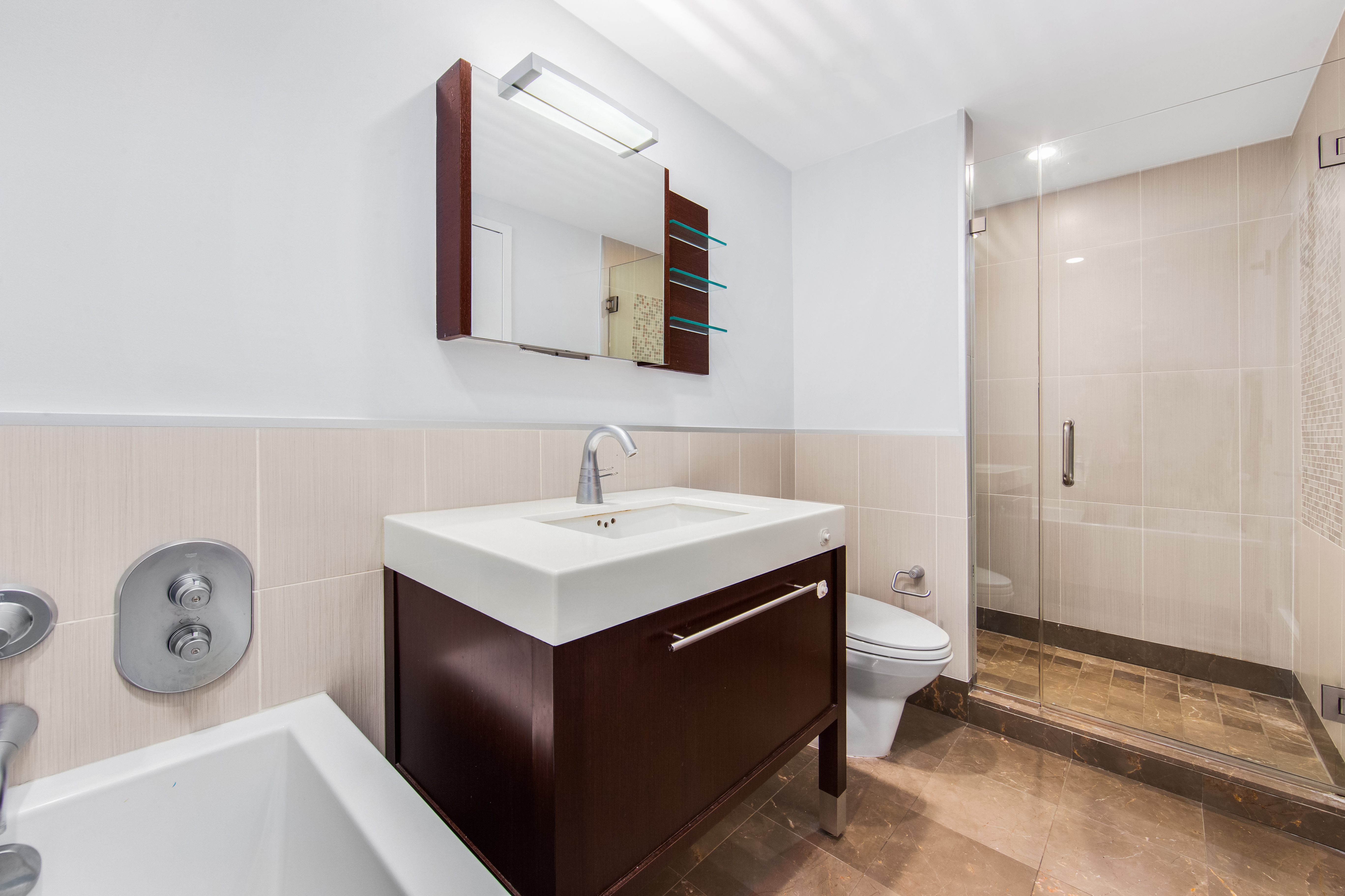 225 East 34th Street, Unit 21I Manhattan, NY 10016 - Photo 10 of 24 a bathroom with a sink toilet and a mirror