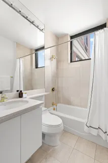 a bathroom with a granite countertop sink a toilet and shower