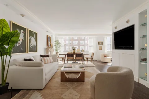 a living room with furniture a flat screen tv and a large window