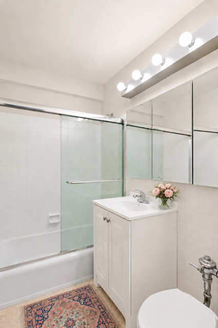15 West 72nd Street, Unit 25F Manhattan, NY 10023 - Photo 8 of 12 a bathroom with a sink mirror toilet and shower