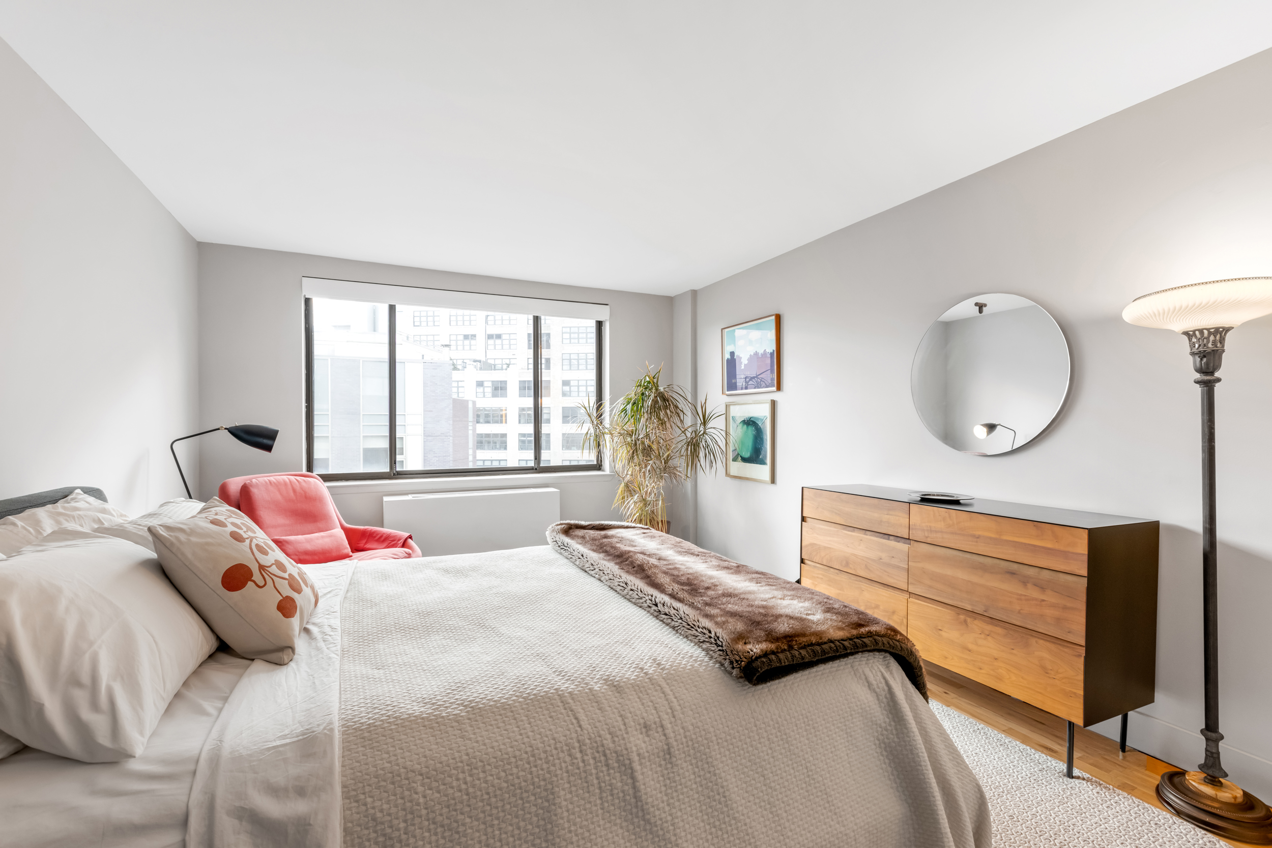 63 Downing Street, Unit 8C Manhattan, NY 10014 - Photo 9 of 15 a bedroom with a large bed and a large window