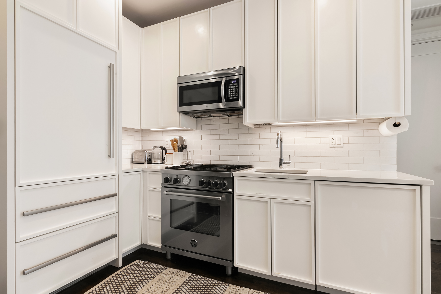558 West 150th Street, Unit 301 Manhattan, NY 10031 - Photo 5 of 8 a kitchen with white cabinets stainless steel appliances and sink
