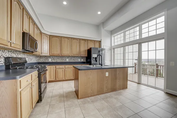 a kitchen with stainless steel appliances granite countertop a stove a sink and a microwave