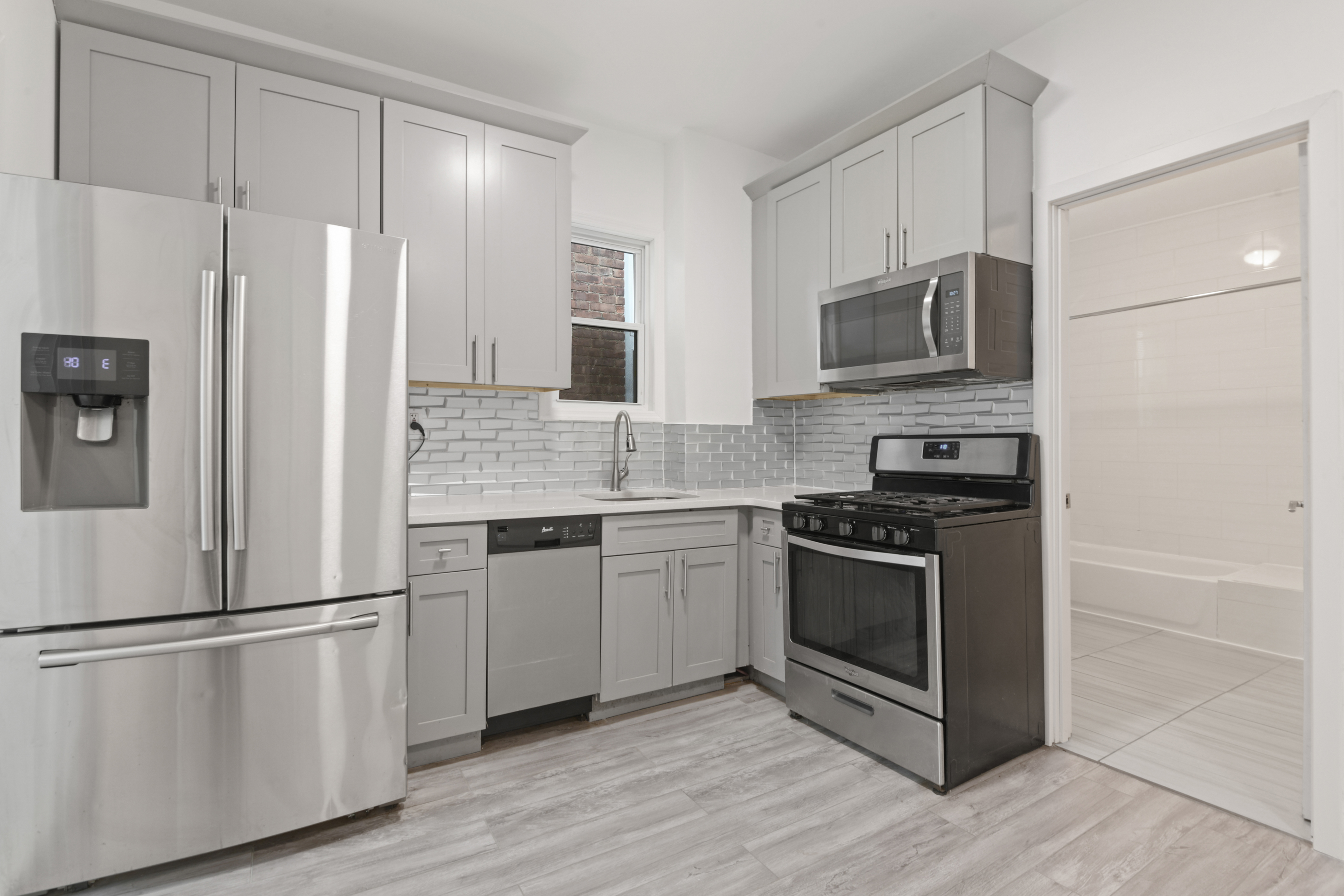 332 East 198th Street, Unit 2 Bronx, NY 10458 - Photo 3 of 10 a kitchen with stainless steel appliances a refrigerator stove and microwave