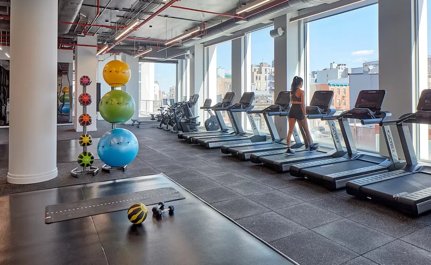 a room with gym equipment and large windows