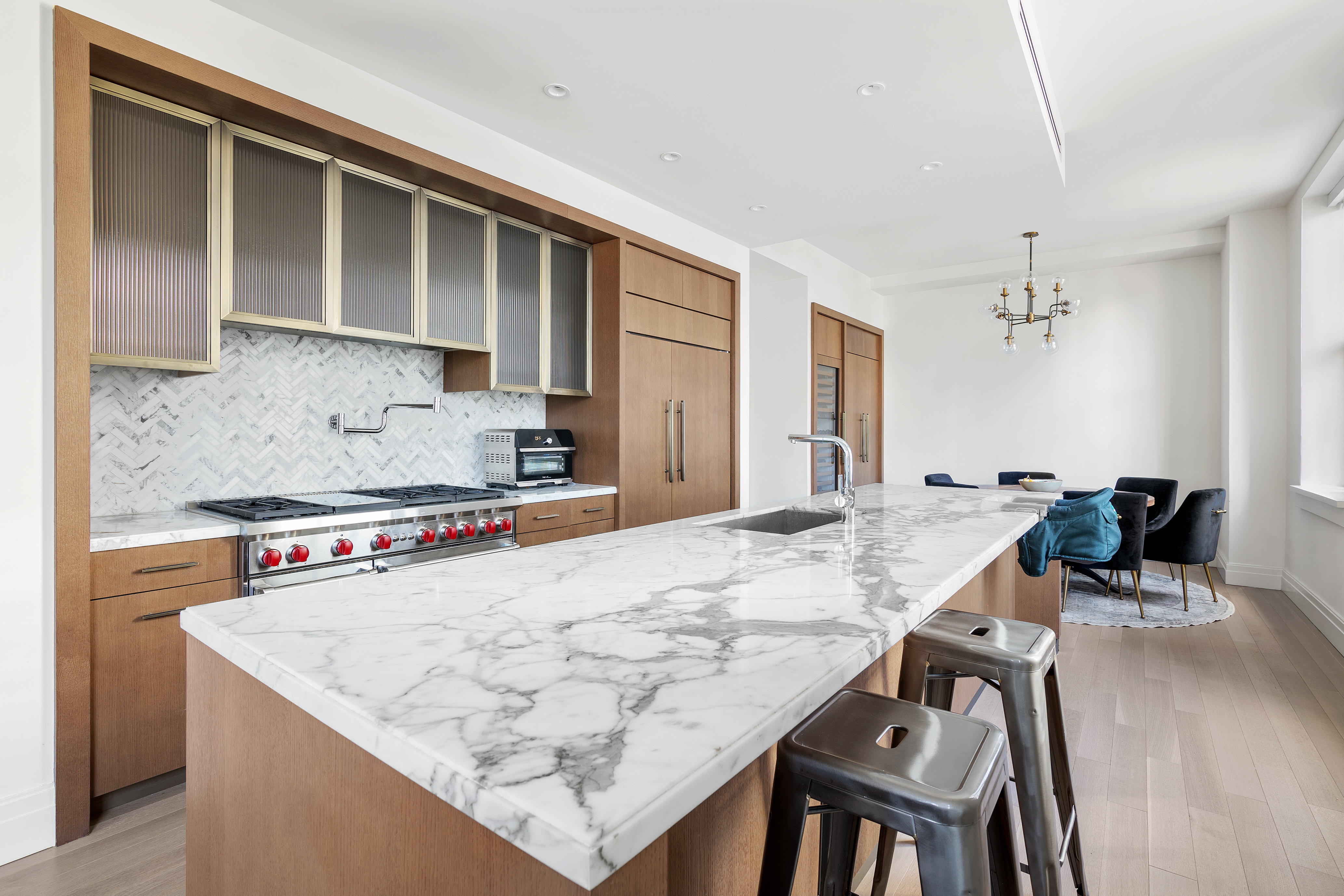 100 Barclay Street, Unit 16D Manhattan, NY 10007 - Photo 2 of 14 a kitchen with a stove a sink a refrigerator and a dining table