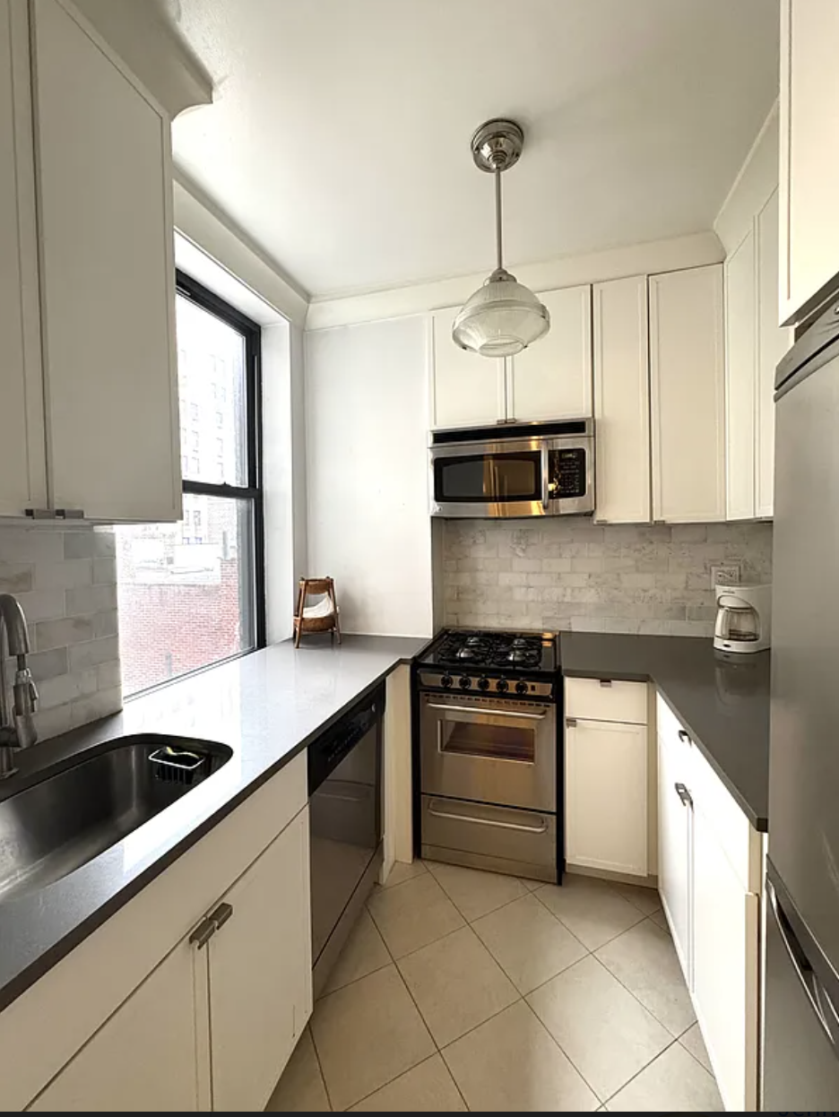 a kitchen with stainless steel appliances granite countertop a sink a stove a microwave and cabinets