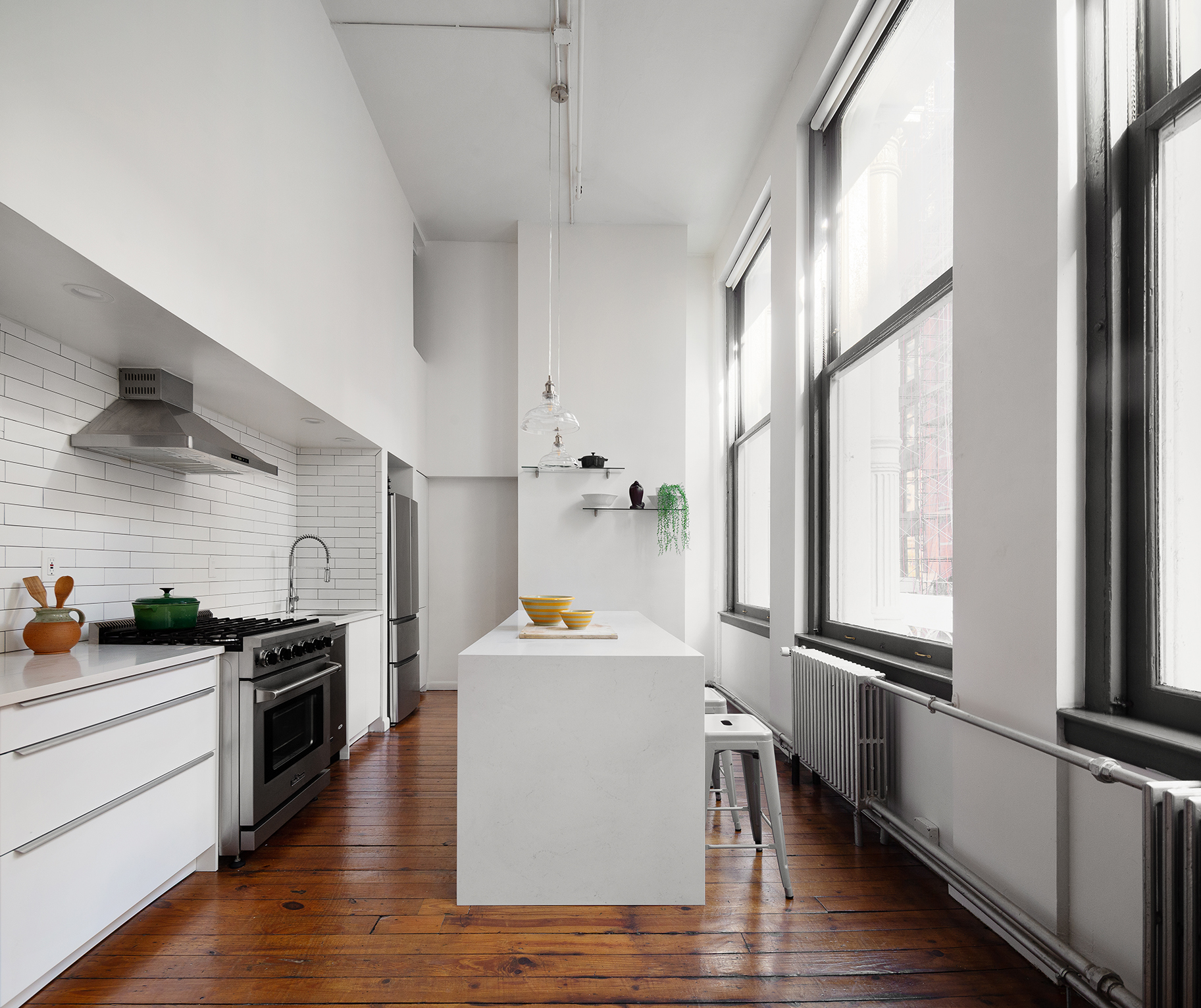 135 Greene Street, Unit 2N Manhattan, NY 10012 - Photo 3 of 13 a kitchen with granite countertop a refrigerator and a stove top oven