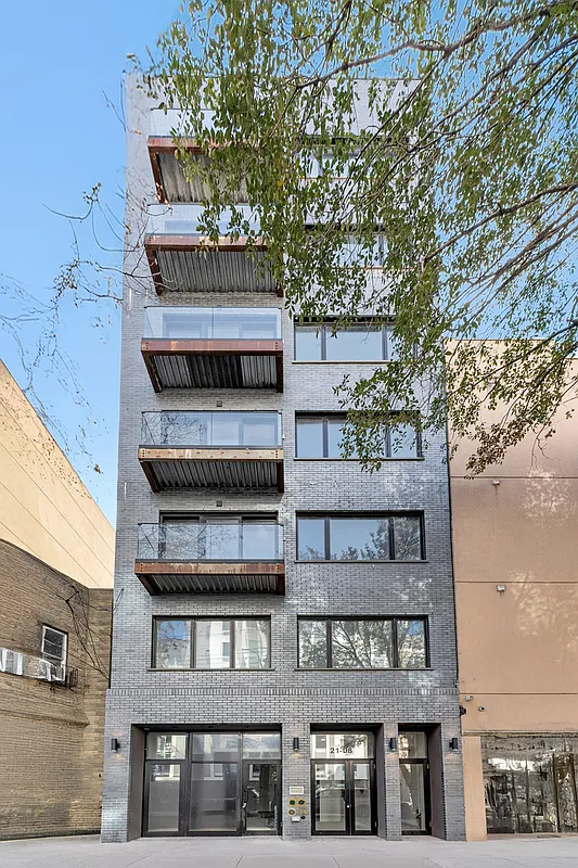 21-10 30th Avenue, Unit 1R Queens, NY 11102 - Photo 12 of 16 a front view of a building with a yard
